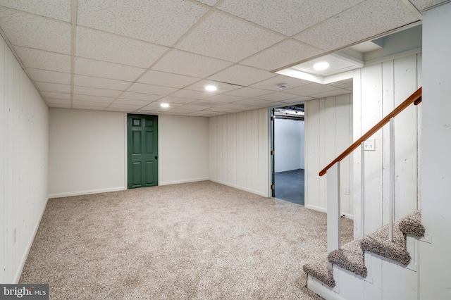 finished below grade area with stairway, a paneled ceiling, recessed lighting, and carpet floors