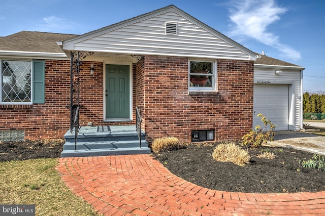view of front of property featuring brick siding and a garage