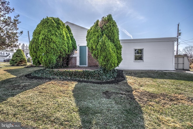 view of front of home featuring an outbuilding, a front yard, and a storage shed