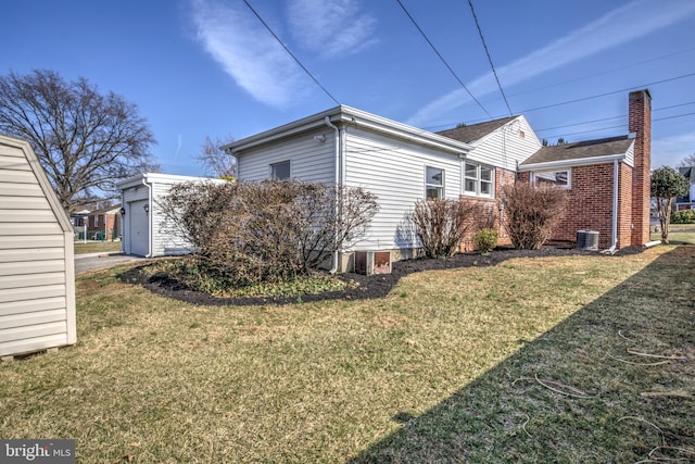view of side of property with central AC and a lawn