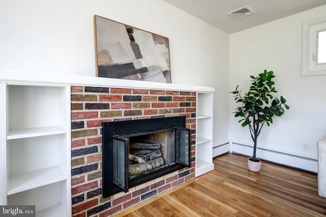 interior details with baseboard heating, visible vents, wood finished floors, and a fireplace