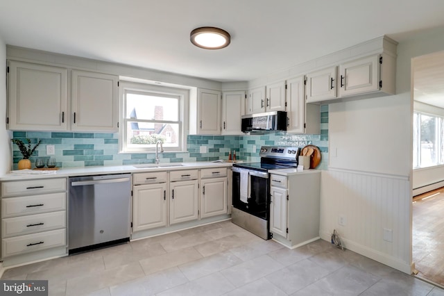 kitchen featuring a wealth of natural light, stainless steel appliances, light countertops, and a sink