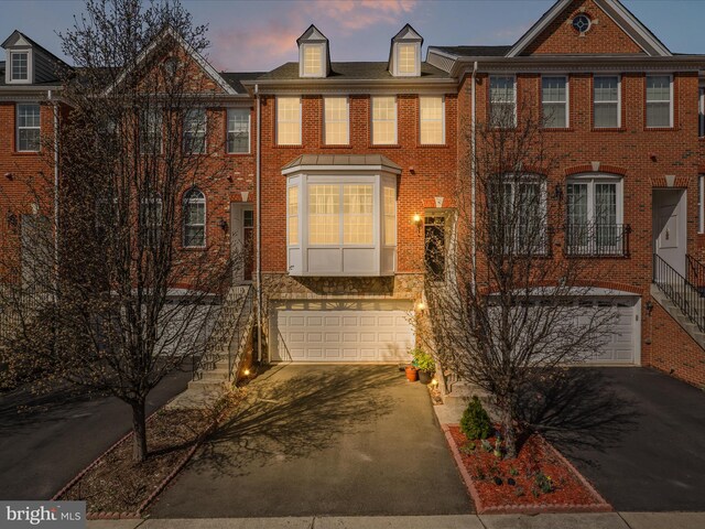 43260 Mitcham Sq, Ashburn, VA 20148 - view of property featuring stairway, brick siding, driveway, and an attached garage