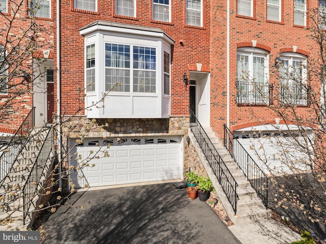 43260 Mitcham Sq, Ashburn, VA 20148 - view of front of home featuring brick siding, a garage, driveway, stone siding, and stairs