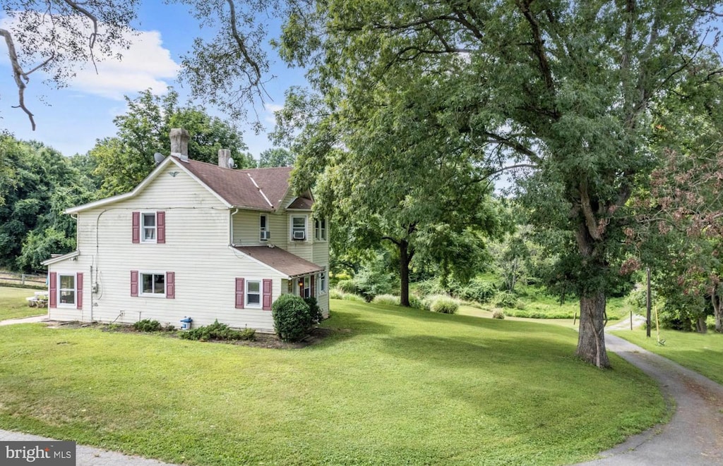 view of property exterior with a chimney and a yard