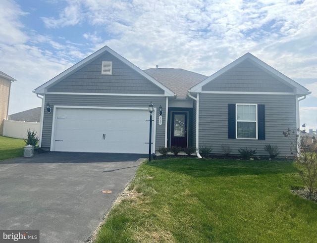 view of front of property with a garage, fence, a front yard, and aphalt driveway