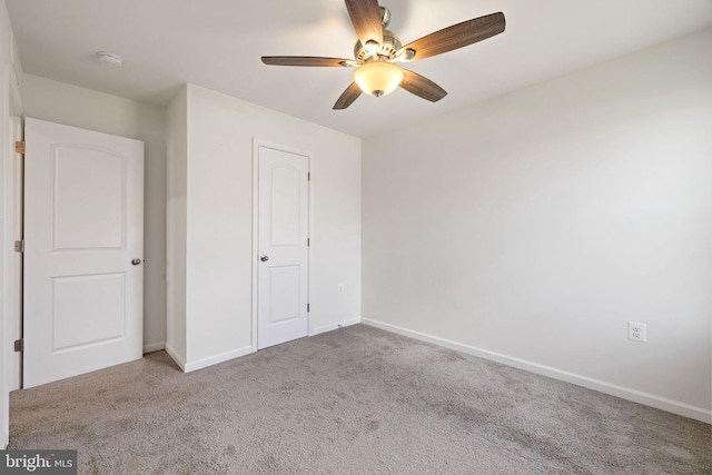 unfurnished bedroom with carpet floors, baseboards, and a ceiling fan