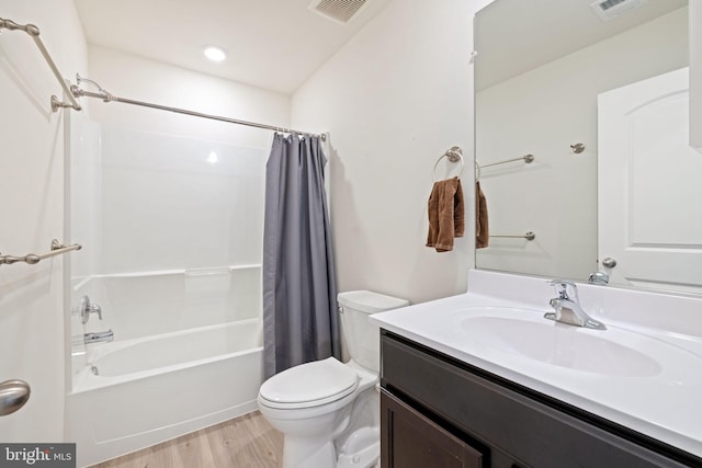 full bath with vanity, toilet, wood finished floors, and visible vents