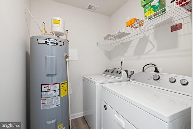 laundry room featuring laundry area, visible vents, baseboards, water heater, and washer and dryer