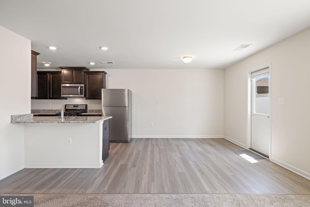 kitchen featuring baseboards, stainless steel appliances, and light wood-style flooring