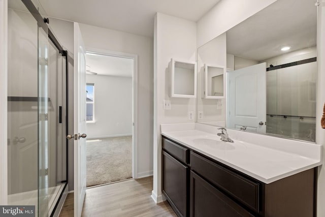 bathroom featuring baseboards, wood finished floors, and vanity