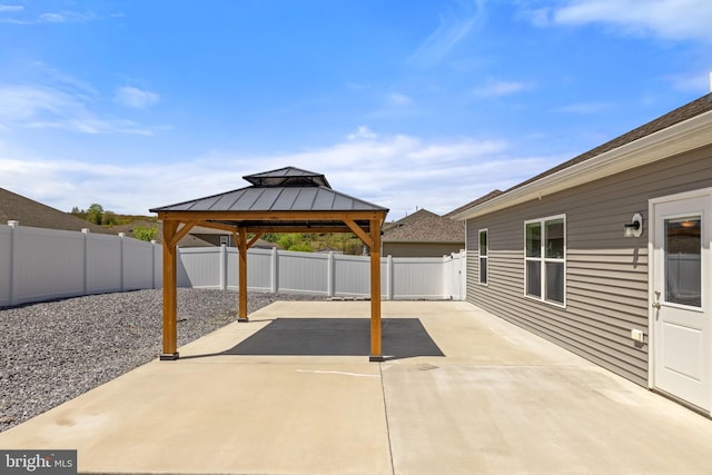 view of patio with a gazebo, driveway, and a fenced backyard