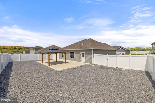 rear view of property with a gazebo, a fenced backyard, and a patio area