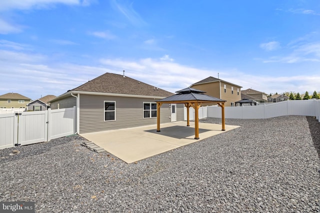 rear view of house with a patio, a gazebo, a gate, and a fenced backyard