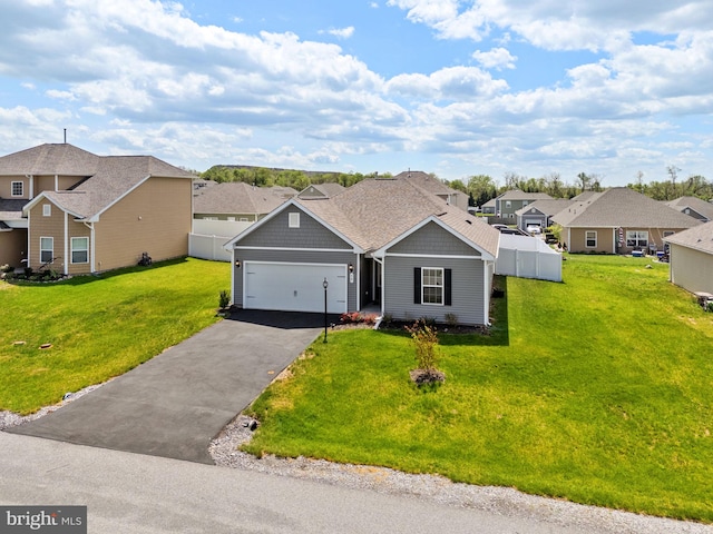 ranch-style house featuring a garage, a front lawn, fence, driveway, and a residential view