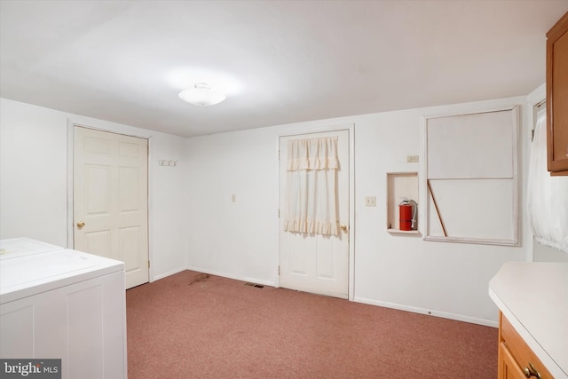 interior space featuring cabinet space, light carpet, washer / clothes dryer, baseboards, and visible vents