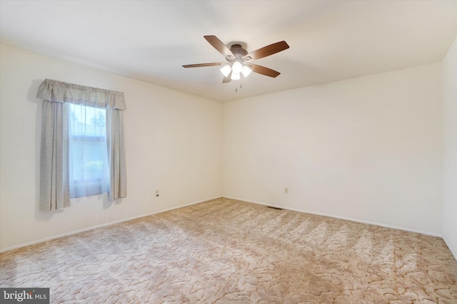spare room with baseboards, a ceiling fan, and carpet flooring