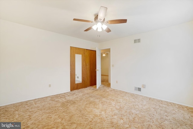 carpeted empty room featuring baseboards, a ceiling fan, and visible vents