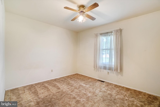 spare room with a ceiling fan, baseboards, visible vents, and carpet