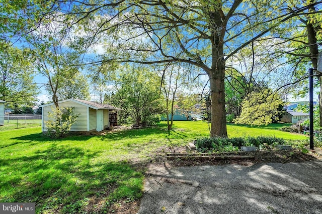 view of yard featuring an outdoor structure and fence
