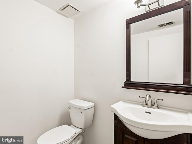 bathroom featuring toilet, visible vents, and vanity