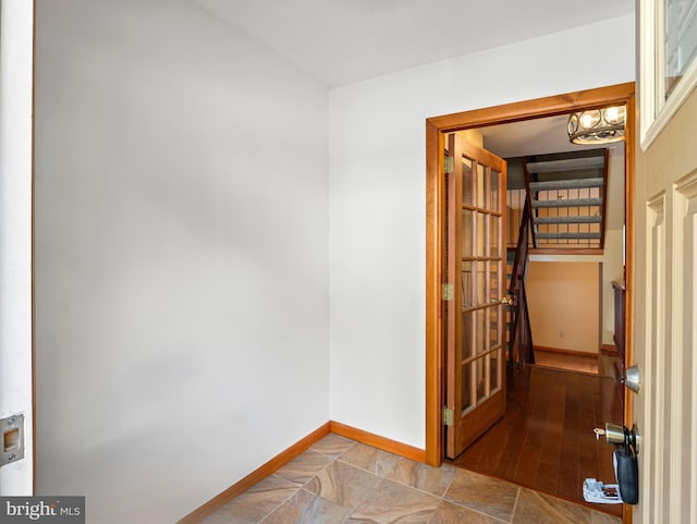 empty room featuring baseboards and stairway