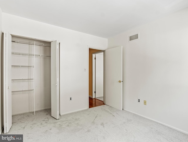 unfurnished bedroom featuring a closet, carpet, baseboards, and visible vents