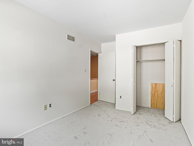 unfurnished bedroom featuring carpet floors, baseboards, visible vents, and a closet