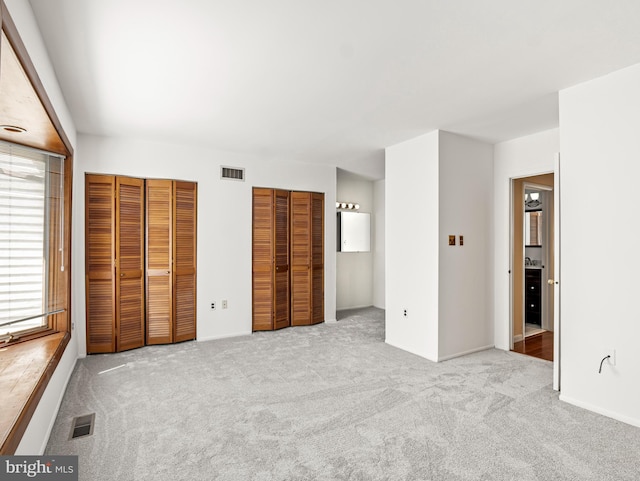 unfurnished bedroom featuring carpet and visible vents