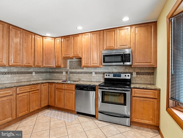 kitchen featuring backsplash, appliances with stainless steel finishes, a sink, light tile patterned floors, and recessed lighting