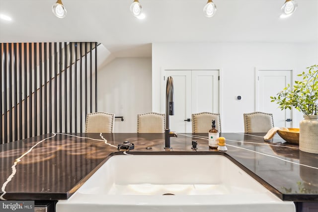 kitchen view of a sink, dark countertops, and recessed lighting