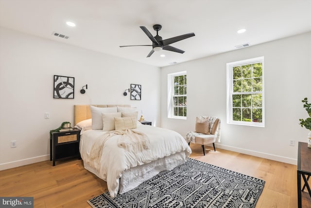 bedroom featuring multiple windows, light wood-type flooring, baseboards, and recessed lighting