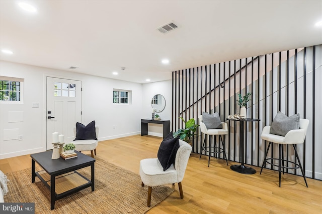 living room featuring wood finished floors, stairway, baseboards, and recessed lighting