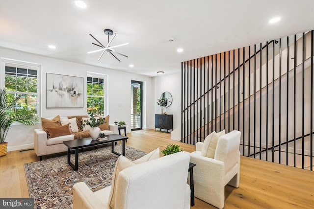 living room featuring wood finished floors, recessed lighting, baseboards, and a chandelier