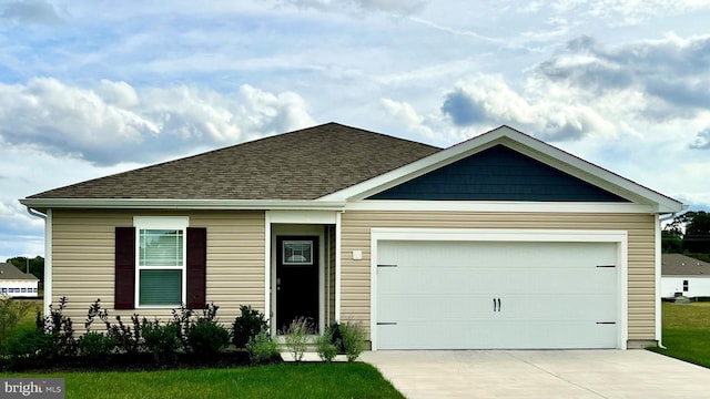 view of front of house with a garage, driveway, and roof with shingles