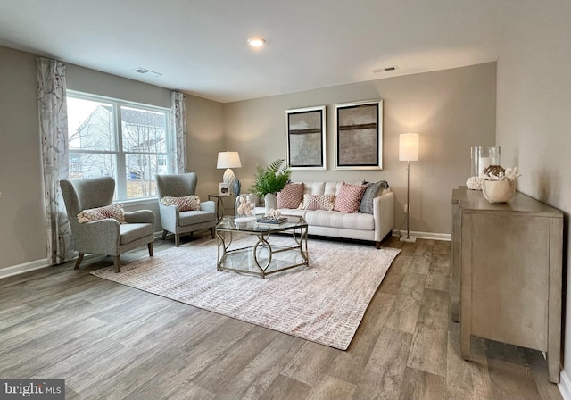 living room with baseboards, visible vents, wood finished floors, and recessed lighting