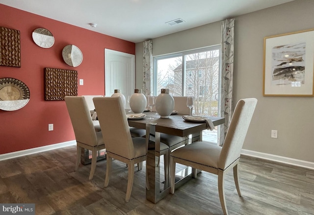 dining space featuring visible vents, wood finished floors, and baseboards