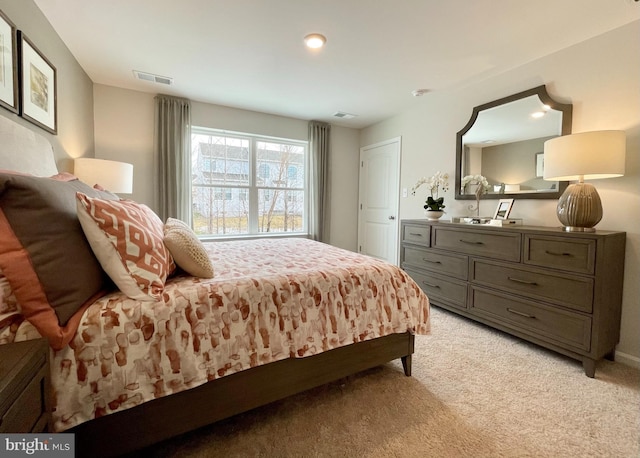 bedroom featuring light colored carpet and visible vents