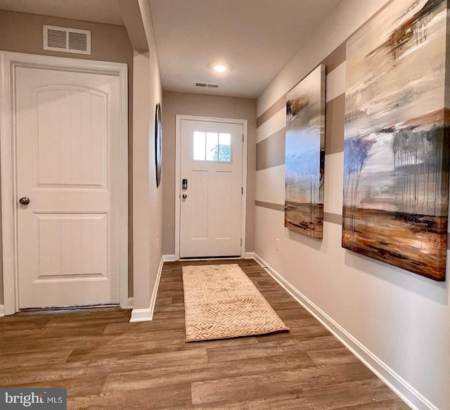 doorway to outside featuring visible vents, wood finished floors, and baseboards