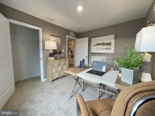 home office featuring visible vents, light carpet, and baseboards