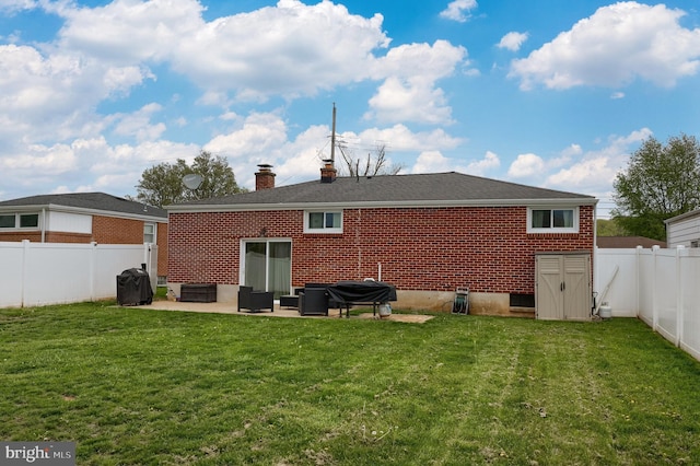 back of house with a patio area, a yard, a chimney, a fenced backyard, and brick siding