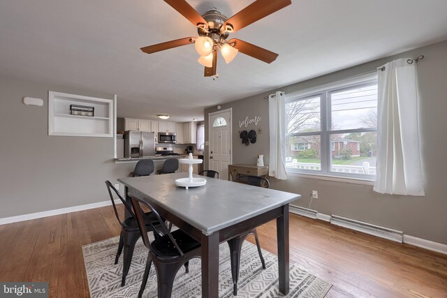dining room featuring baseboards, visible vents, wood finished floors, and ceiling fan