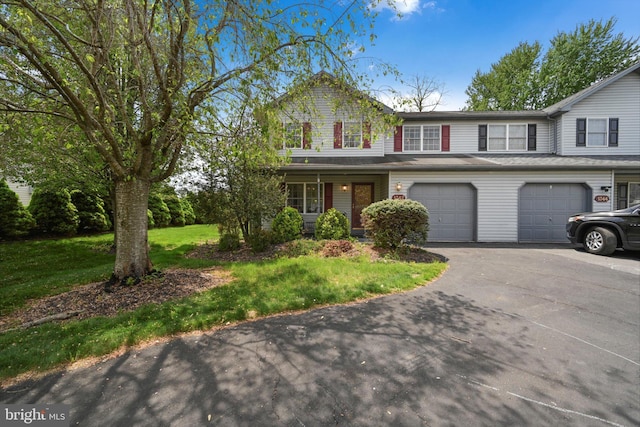traditional home featuring a garage, driveway, and a front yard