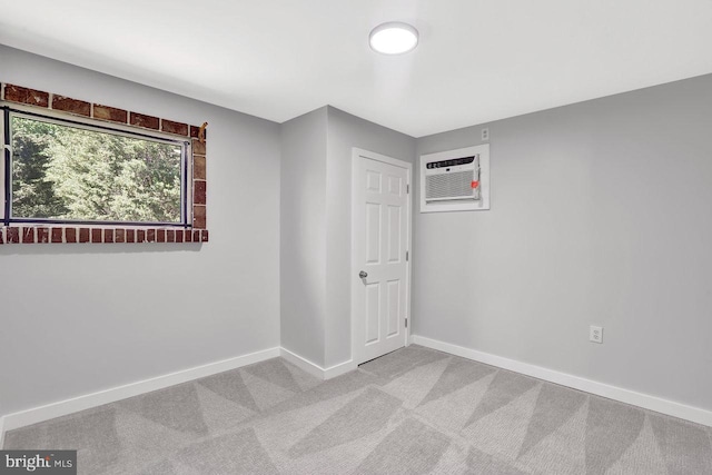 spare room featuring baseboards, a wall mounted AC, and carpet flooring