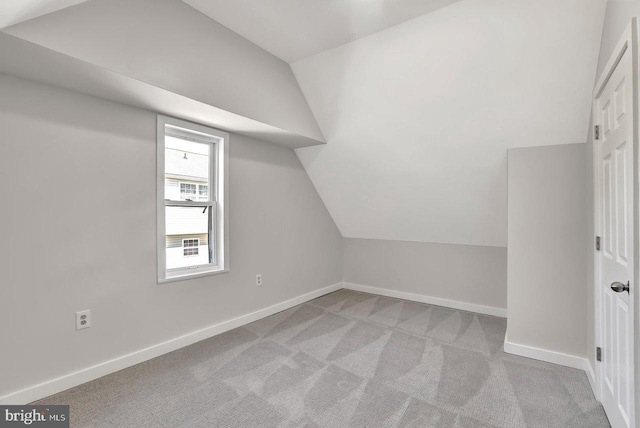 bonus room with carpet floors, baseboards, and vaulted ceiling