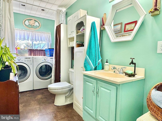 bathroom with toilet, vanity, and washing machine and dryer