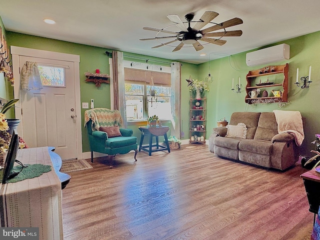 living area with recessed lighting, an AC wall unit, a ceiling fan, and wood finished floors