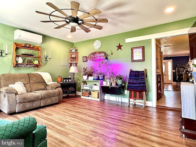 living area with a wall mounted air conditioner, recessed lighting, ceiling fan, and wood finished floors