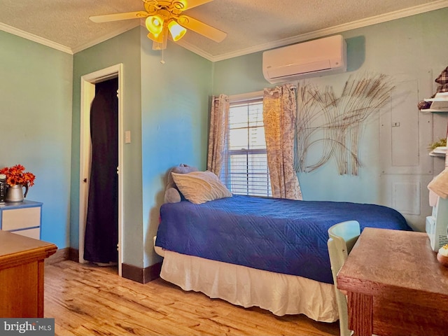 bedroom with a textured ceiling, crown molding, ceiling fan, wood finished floors, and a wall mounted air conditioner