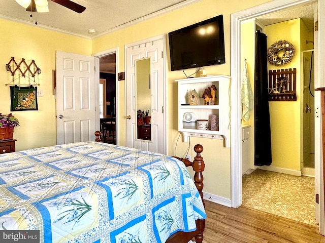 bedroom with wood finished floors, ornamental molding, ceiling fan, baseboards, and a textured ceiling